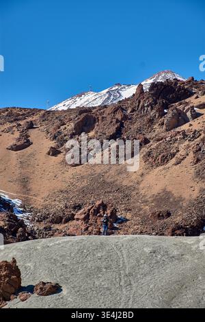 Teide, Teneriffa, 13. Januar 2026, Eine Gruppe von Besuchern spaziert entlang der Wege von ockerem Sand und Basaltfelsen, die sich am Fuße des imposanten Mo erstrecken Stockfoto