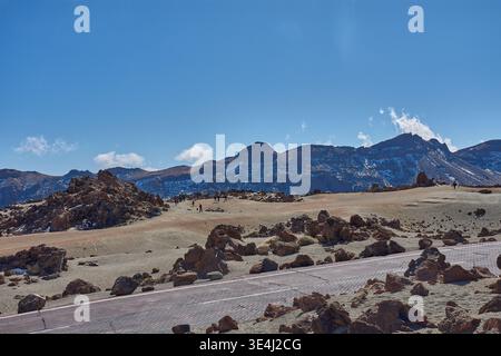 Teide, Teneriffa, 13. Januar 2026, Eine Gruppe von Besuchern spaziert entlang der Wege von ockerem Sand und Basaltfelsen, die sich am Fuße des imposanten Mo erstrecken Stockfoto