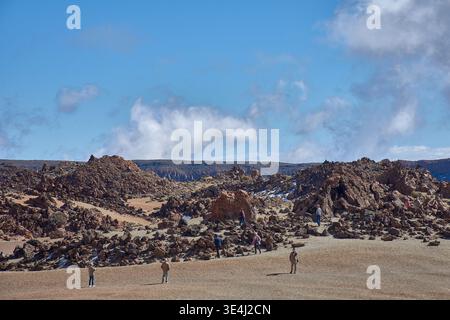 Teide, Teneriffa, 13. Januar 2026, Eine Gruppe von Besuchern spaziert entlang der Wege von ockerem Sand und Basaltfelsen, die sich am Fuße des imposanten Mo erstrecken Stockfoto