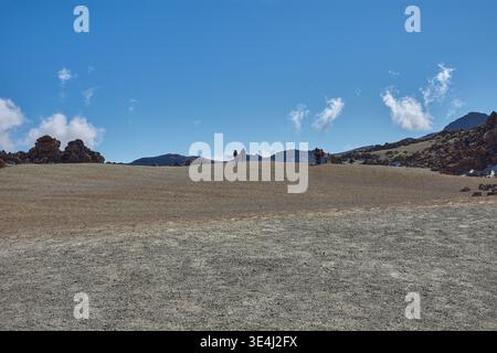 Teide, Teneriffa, 13. Januar 2026, Eine Gruppe von Besuchern spaziert entlang der Wege von ockerem Sand und Basaltfelsen, die sich am Fuße des imposanten Mo erstrecken Stockfoto
