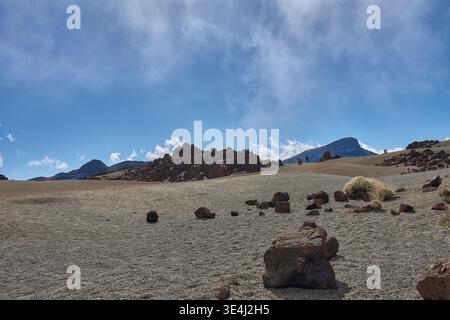 Teide, Teneriffa, 13. Januar 2026, Eine Gruppe von Besuchern spaziert entlang der Wege von ockerem Sand und Basaltfelsen, die sich am Fuße des imposanten Mo erstrecken Stockfoto