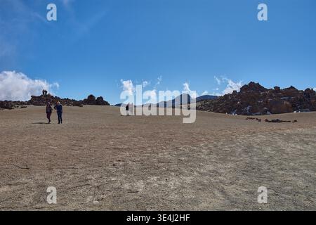 Teide, Teneriffa, 13. Januar 2026, Eine Gruppe von Besuchern spaziert entlang der Wege von ockerem Sand und Basaltfelsen, die sich am Fuße des imposanten Mo erstrecken Stockfoto
