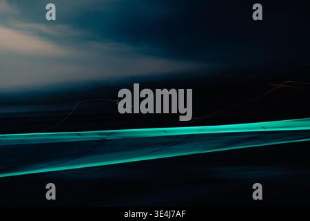 Abstrakter Hintergrund mit einem hellen, blauen Streifen, der über eine dunkle Szene mit Bewegungsunschärfe schwingt und eine elegante futuristische Atmosphäre und ein minimales Minimum schafft Stockfoto