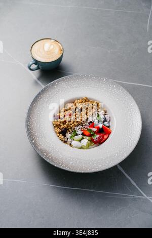 Blick von oben auf die Müslischale mit gebackenem Hafer, Erdbeerscheiben, Heidelbeere, grüner Traube, frischer Minze und Puderzucker, serviert mit Joghurt oder Milch auf einem gr Stockfoto