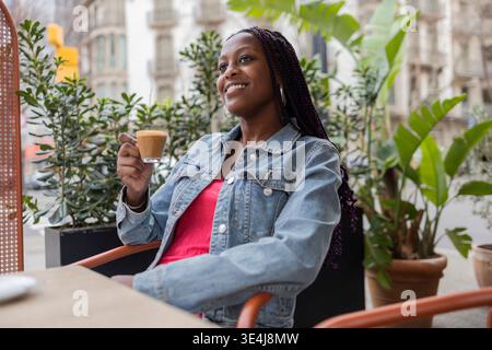 Eine Frau genießt einen Kaffee in einem Café auf der Straße Diagonal im lebhaften Stadtviertel Gracia in Barcelona, Spanien, das die entspannte und lebhafte Stadt verkörpert Stockfoto