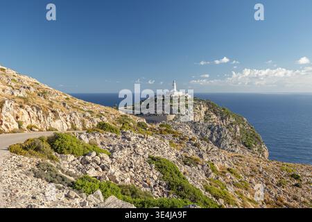 Gewundene Straße, die zum Leuchtturm Far de Formentor an der Nordspitze Mallorcas führt, umgeben von felsigen Klippen, Blick auf das Mittelmeer und hell klar Stockfoto