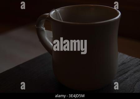 Minimaler weißer Becher mit Teebeutel-Schnur auf Holztisch Stockfoto