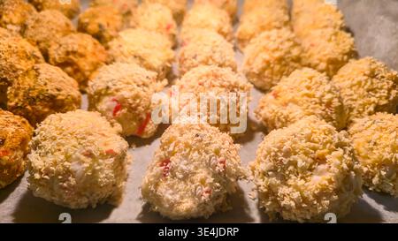 Knusprige panierte Reiskroketten, im Ofen goldbraun gebacken. Moderne Hausmannskost, asiatisch inspirierte Küche, Nahaufnahme des fertigen Gerichts. Stockfoto