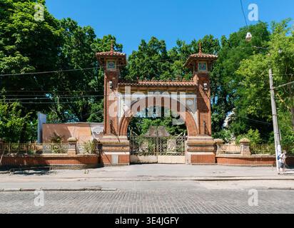Odesa, Ukraine - 11. Juli 2025: Monumentaler Eingangsbogen aus rotem Backstein der historischen Schaumweinfabrik Odesa mit zwei Seitentürmen Stockfoto