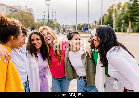 Verschiedene junge Frauen stehen nahe und lächeln draußen Stockfoto