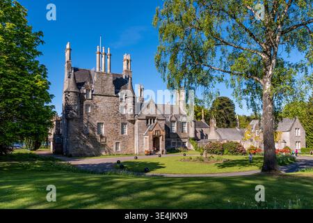 Das historische Laurieston Castle befindet sich neben gepflegten Gärten und Parklandschaften entlang der Cramond Road in Schottland, eingerahmt von Reifen Bäumen und blauem Himmel, was die h Stockfoto