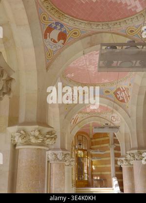 Gewölbter Korridor mit rosa Fischgrätenmosaikdecken, heraldischen Schiffsmotiven und 1905 Inschrift in der Recinte Modernista de Sant Pau, Barcelona Stockfoto