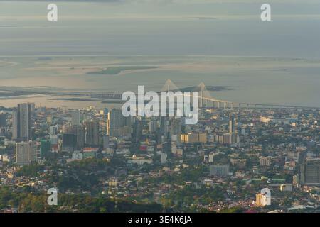 Cebu City, Philippinen – 7. April 2025: Ein Teleobjektiv zeigt die Skyline von Cebu City mit einer Kabelbrücke und Küstengewässern im Hintergrund. Stockfoto