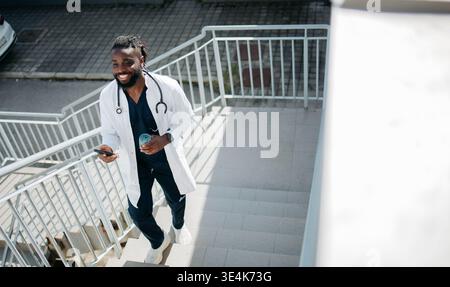 Arzt in Pause mit Telefon Stockfoto