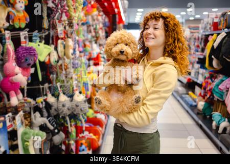 Eine junge Frau mit Pudel im Tierhandwerk Stockfoto
