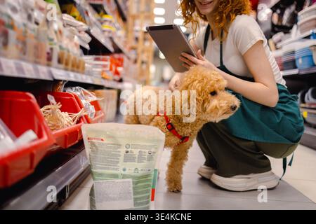 Eine junge Frau mit Pudel im Tierhandwerk Stockfoto