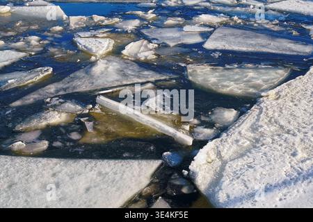 Hochwinkelansicht von gebrochenen Eisblöcken auf einem Fluss. Ideal für Klimaänderungen, globale Erwärmung und Winternaturkonzepte. Stockfoto