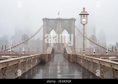 Brooklyn Bridge an einem regnerischen und nebeligen Tag mit der Skyline von Manhattan in der Ferne, New York City, New York, USA Stockfoto