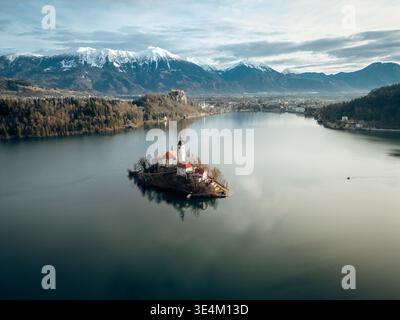 Sonnenaufgangsflug auf der Insel Bleder See, Slowenien, Landschaft der Julischen Alpen mit Kirche und ruhigem Wasser Stockfoto