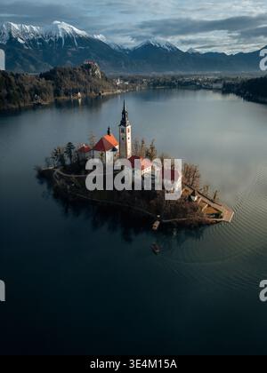 See Bleder Insel von oben, Slowenien, berühmte Kirche auf der Insel mit alpinen Bergen Hintergrund Stockfoto