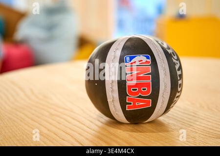 Nahaufnahme eines schwarzen Miniaturbasketballs mit auffälligem NBA-Logo auf der Oberfläche. Der Ball hat weiße, genähte Streifen und Stockfoto