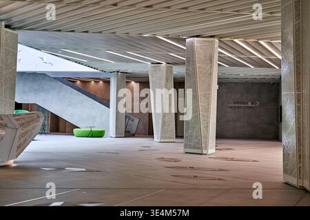 Eine moderne, geräumige Innenlobby oder ein Atrium mit modernem architektonischen Design. Der Raum umfasst mehrere hohe, sich verjüngende Stützsäulen Stockfoto
