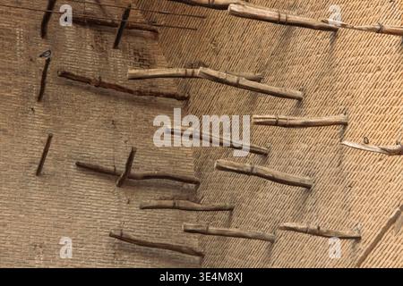 Kompliziertes architektonisches Design mit Holzbalken vor einem strukturierten Wandhintergrund in einer einzigartigen Struktur Stockfoto