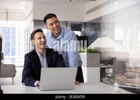 Zwei verschiedene Kollegen planen zukünftige Ziele am Schreibtisch per Laptop Stockfoto