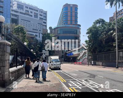 Urbane Perspektive einer Straße, die zur Kreuzung der Prince Edward Road West in Hongkong führt, mit modernen Wolkenkratzern und Stadtarchitektur. Stockfoto