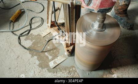 Der leistungsstarke Bohrer mit Diamantspitze bohrt Löcher für die Kommunikation im Haus. Draufsicht Stockfoto