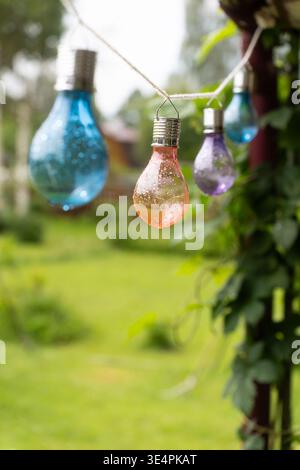 Dekoration mit brennenden Lampen auf Holzsteg. Terrasse mit elektrischen Lampen als Girlande, Holzterrasse in der Nähe des Sees, Pier. Romantische Atmosphäre .Roma Stockfoto