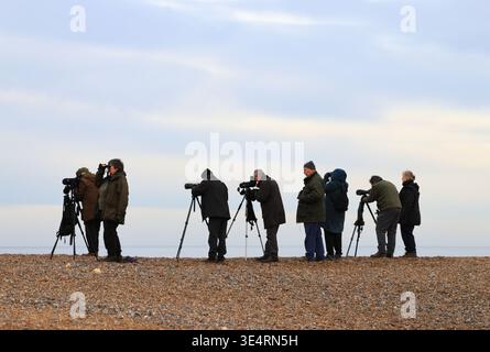 Eine Gruppe von Vogelbeobachtern am Kiesstrand mit Blick auf die Nordsee an der Küste von Norfolk bei Cley Next the Sea, Norfolk, England, Großbritannien. Stockfoto