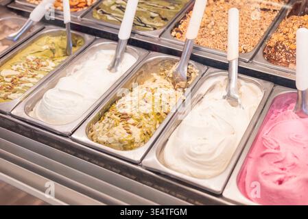 Nahaufnahme verschiedener Geschmacksrichtungen von handwerklichem italienischem Eis in Metallbehältern in einer traditionellen Eisdiele in Italien. Stockfoto