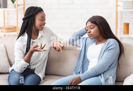 Junge Afroamerikanerin müde von ihrem gesprächigen Freund Stockfoto