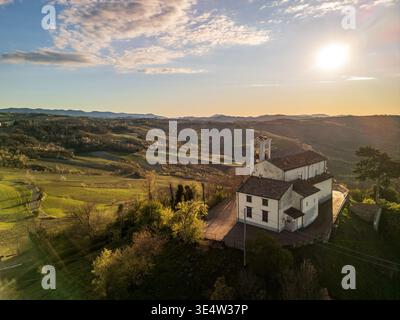 Luftaufnahme der San Giacomo Kirche in Gaianazzo bei Sonnenuntergang. Dieses historische religiöse Gebäude steht auf einem malerischen Hügel, umgeben von Oltrepo Pavese Stockfoto