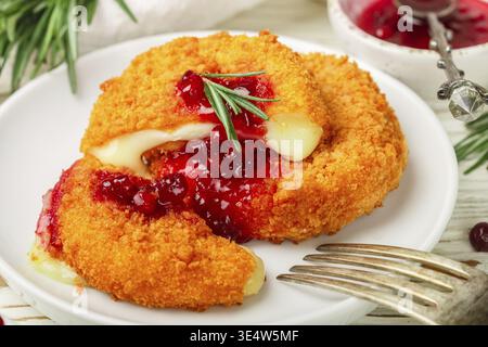 Speisen, gebackener oder gebratener Camembert oder Brie Käse mit Preiselbeere und Rosmarinsauce. Gourmet-Frühstück. Selektiver Fokus Stockfoto