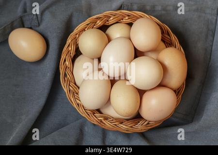 Essen, rohe braune Hühnereier in einem Korb. Ostern. Rustikaler Stil. Weichzeichner, Kopierbereich, Draufsicht Stockfoto