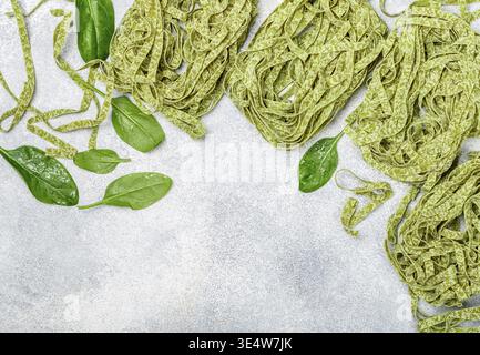 Essen, rohe hausgemachte italienische grüne Pasta Tagliatelle. Trockene Nudeln und Zutaten (Spinat, Mehl, Ei). Selektiver Fokus, Draufsicht, Kopierbereich Stockfoto