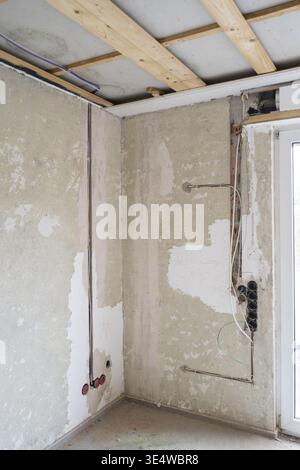 Apartment wird renoviert, Steckplätze für Stromleitungen, unverputzte Steckdosen, Holzkonstruktion unter der Decke, altes Gebäude, Nordrhein-W Stockfoto