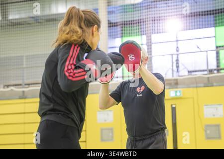 Eine Frau während des Boxtrainings, begleitet von einem Trainer, der Handschützer hält, Boxen TSV Calw, Deutschland Stockfoto