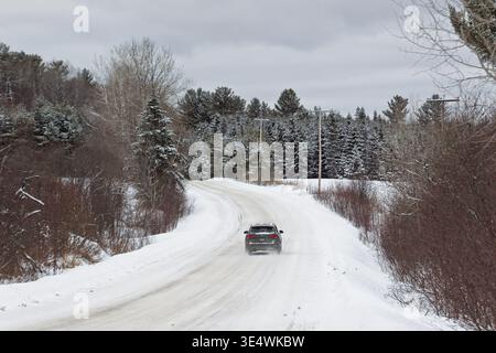 Ein Fahrzeug, das auf einer verschneiten Landstraße fährt, Quebec, Kanada Stockfoto