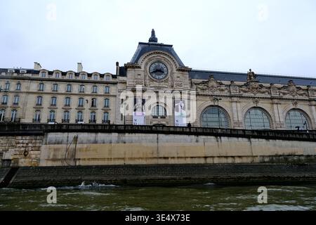 Paris, Frankreich-3. Oktober 2025: Blick auf die Fassade des Musée d'Orsay mit seiner berühmten Uhr und Steindamm entlang der seine Stockfoto