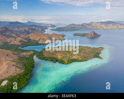 Bei einem atemberaubenden Blick aus der Luft auf den Komodo-Nationalpark in Indonesien zeigt sich türkisfarbenes Wasser mit üppigen Inseln in einem lebendigen Wandteppich der Natur Stockfoto