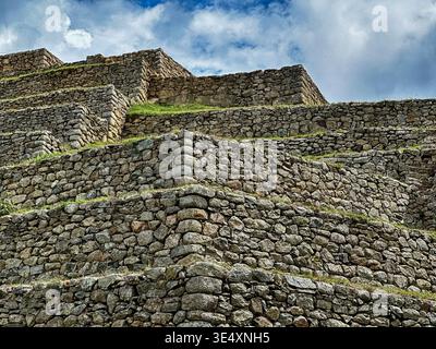 Terrassen und Steinmauern definieren Teile der alten Inkaruinen von Machu Picchu in Peru. Stockfoto