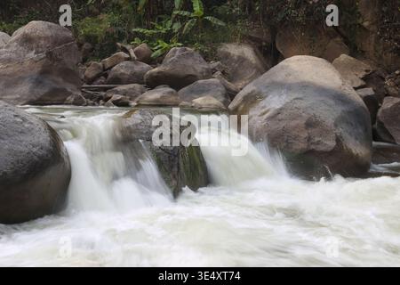 Friedliches Flusswasser, das schnell über große Natursteinblöcke fließt und kleine malerische Wasserfälle schafft, die eine ruhige, ruhige Emotion in Schönheit hervorrufen Stockfoto