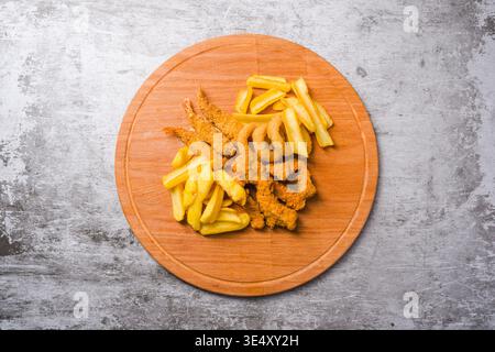 Blick von oben auf gebratene Hähnchennuggets, Garnelen-Zwiebelringe und Pommes frites Stockfoto