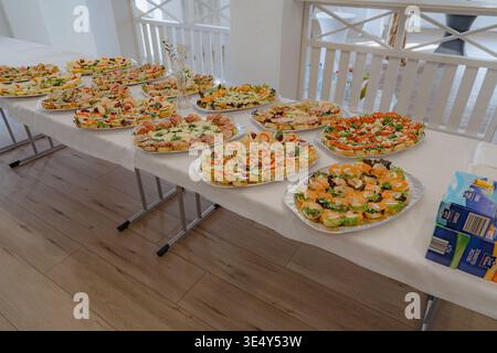 Großer Blick auf das komplette Buffet mit mehreren Catering-Platten und Vorspeisen. Perfekt für große Veranstaltungen, Hochzeiten und Catering-Service Stockfoto