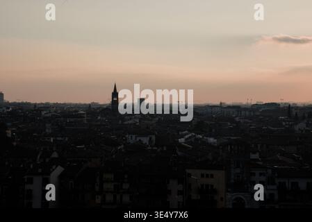 Ein ruhiger Sonnenuntergang wirft ein warmes Licht über die weitläufige historische Stadtlandschaft und hebt die architektonischen Wahrzeichen und das geschäftige urbane Leben hervor. Stockfoto