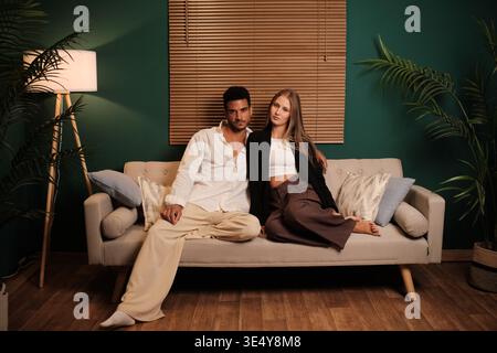 Interrassisches Paar, das sich auf der Wohnzimmercouch entspannt Stockfoto
