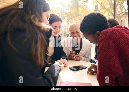 Verschiedene Freunde lachen und teilen Inhalte auf Smartphones Stockfoto